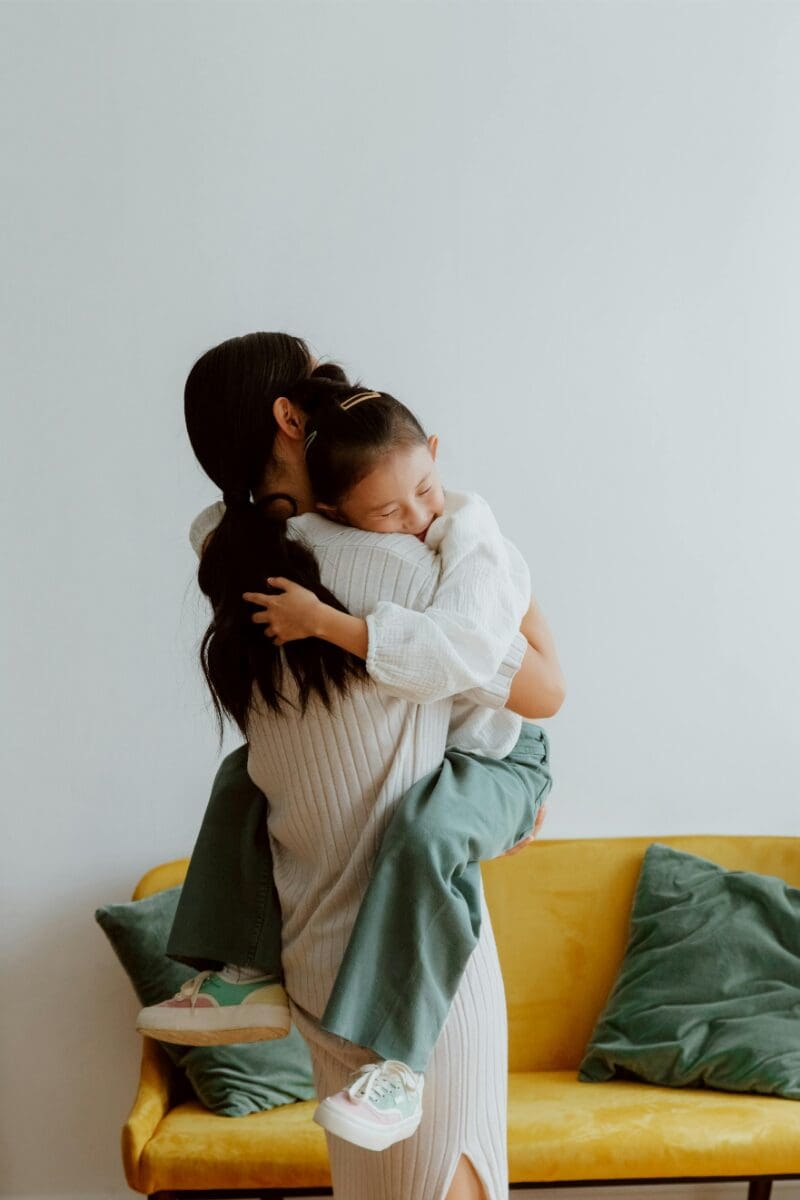 Mother offers her calm presence as she holds upset daughter to comfort her.