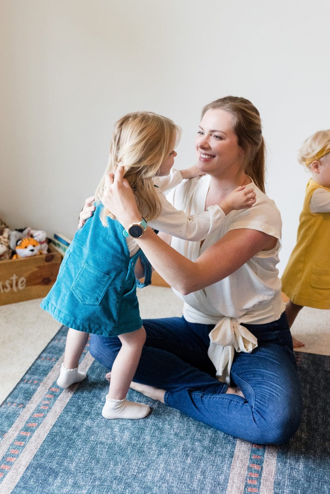Parent coach, Amy Fink, kneeling down to meet a young child at eye level, offering a calm and steady presence.